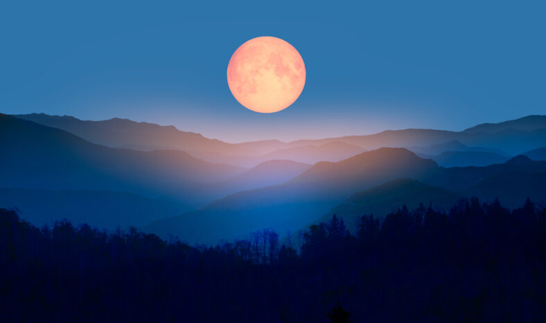 Beautiful landscape with blue misty silhouettes of mountains against super blue moon "Elements of this image furnished by NASA"