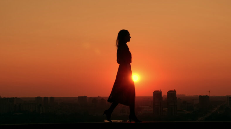 woman walking cityscape at dawn