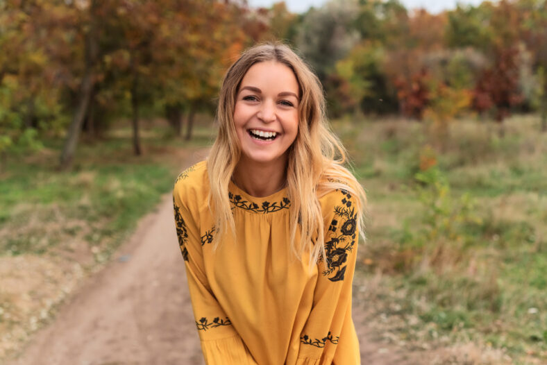 Pretty woman with long blond hair in autumn park