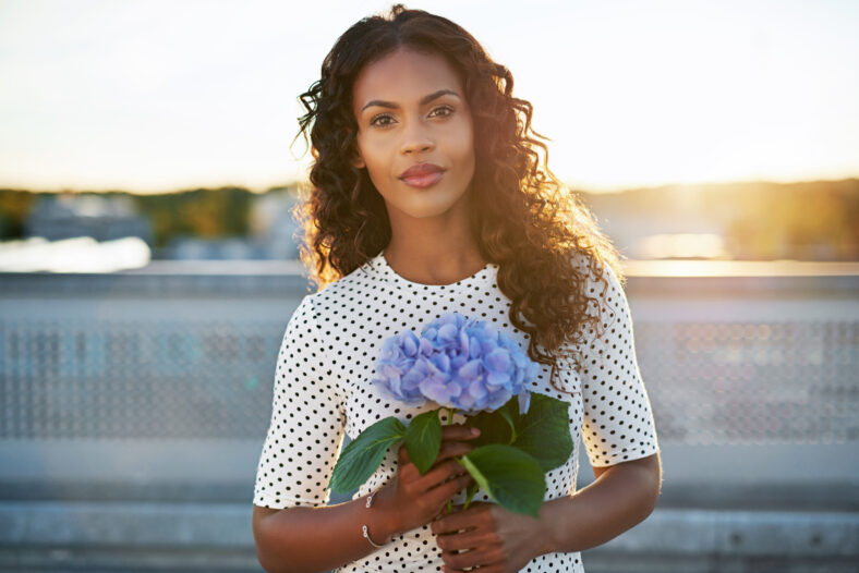Portrait of a pretty african american woman holding a flower