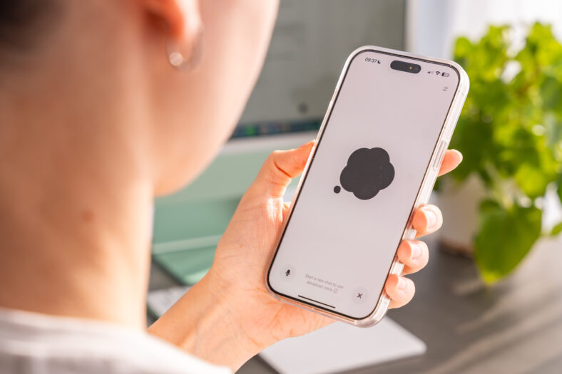 Back view of woman holding Iphone with Chat Gpt application on screen. Work assistant with Open Ai. Artificial Intelligence concept. High quality photo