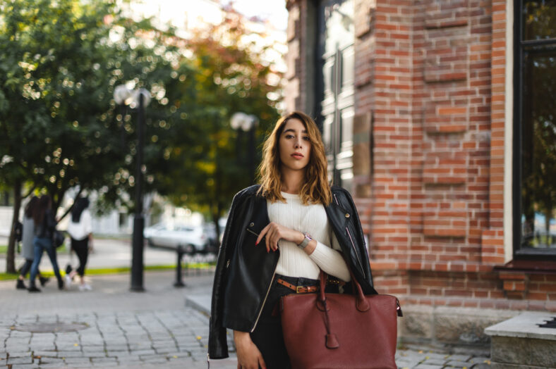 portrait of a young beautiful woman on street, model posing, women's urban street fashion, warm colors