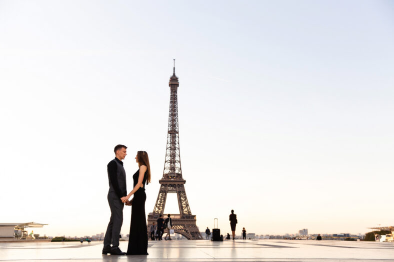 Love in Paris. Romantic couple holding hands on the background of the Eiffel Tower. Honeymoon, date, wedding, marriage in France