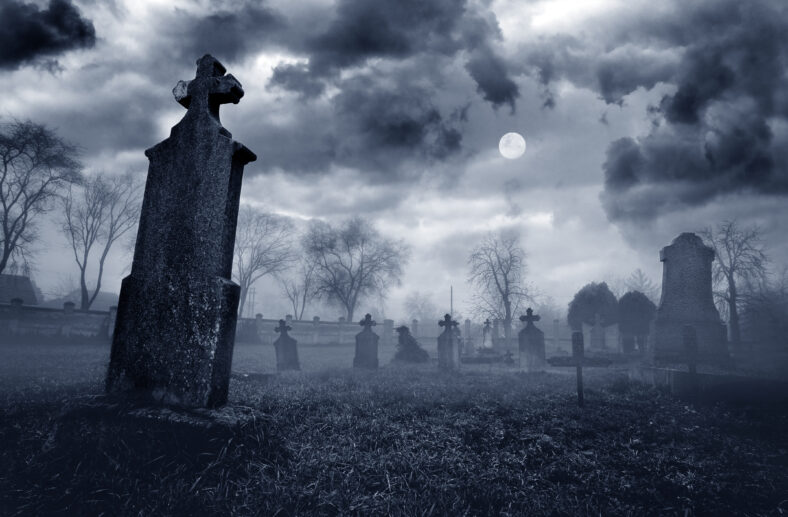 Old creepy graveyard on stormy winter day in black and white.