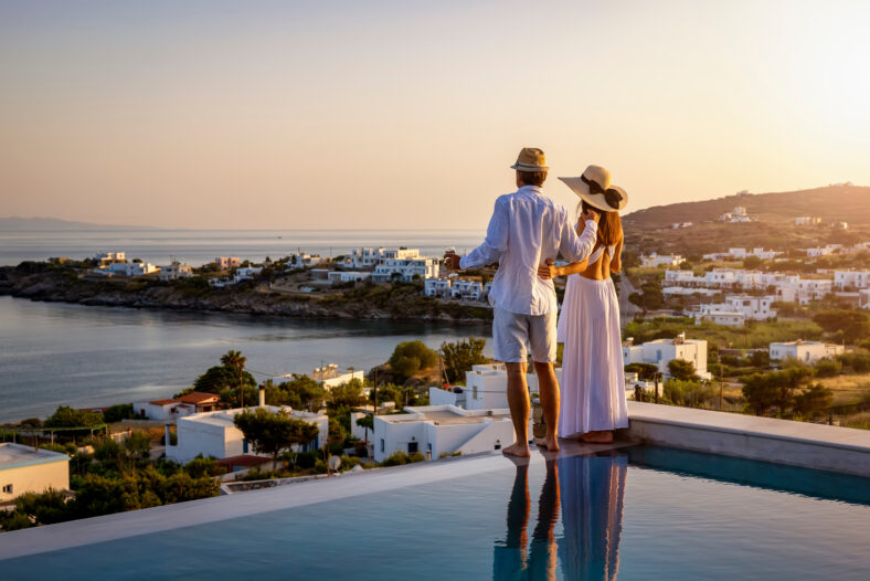 Happy couple on vacation time enjoys the summer sunset over the