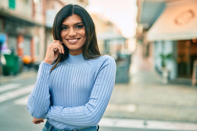 Beautiful hispanic woman smiling confient at the city