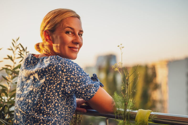 woman looking over her shoulder while standing on a balcony