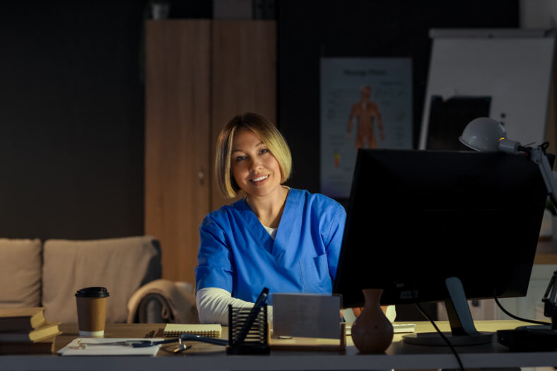 Female nurse working evening shift at table in clinic