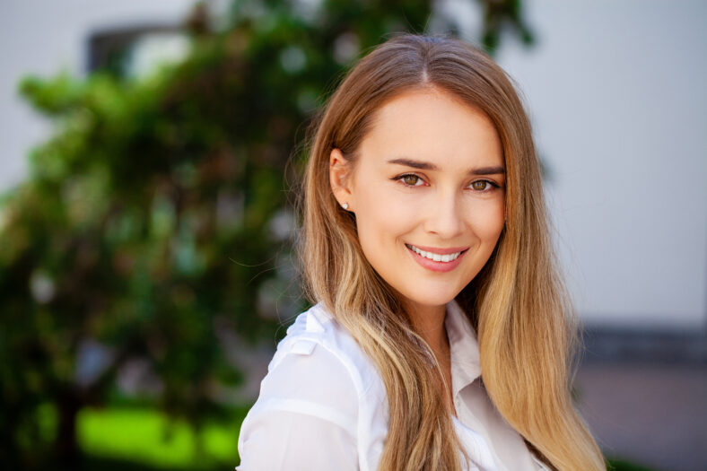 Secretaria Happy Woman. Retrato de primer plano, joven rubia de negocios en camisa blanca en Summer Street City