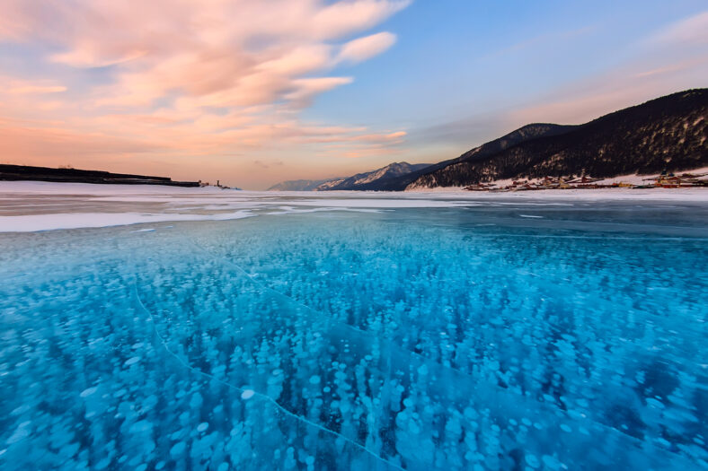 Bubbles of methane gas frozen into clear ice lake baikal, russia.