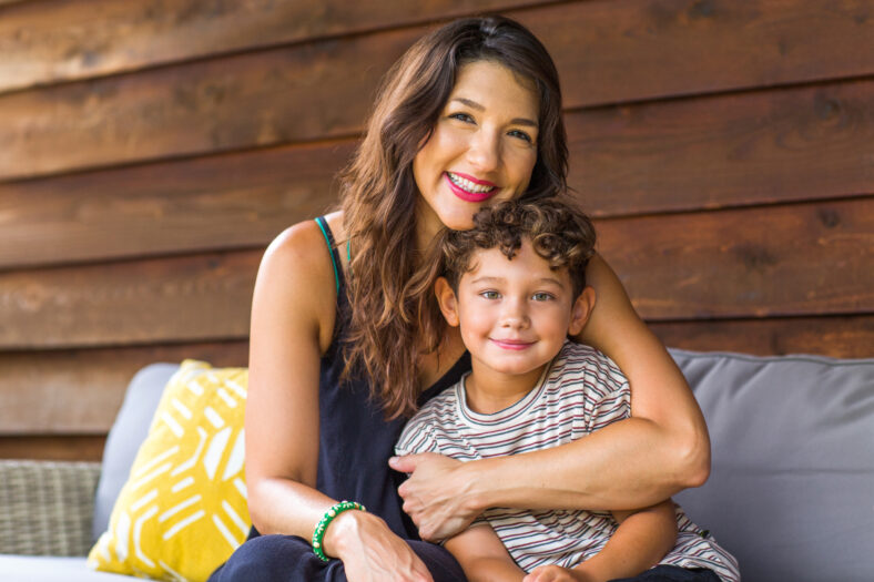 Hispanic mother sitting and hugging her son.