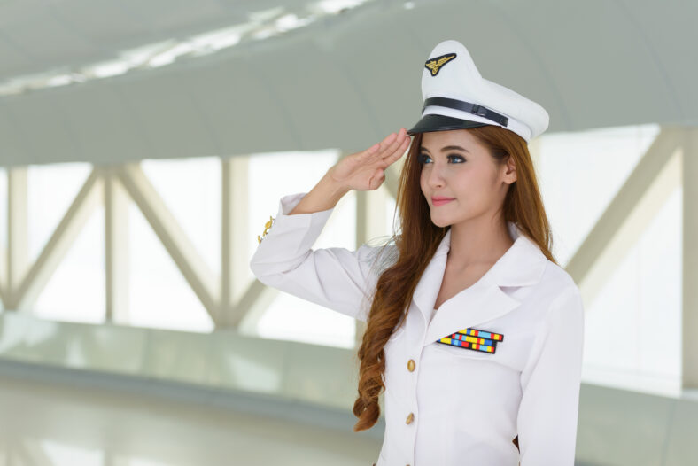 Portrait of young beautiful Asian navy woman wearing uniform indoors