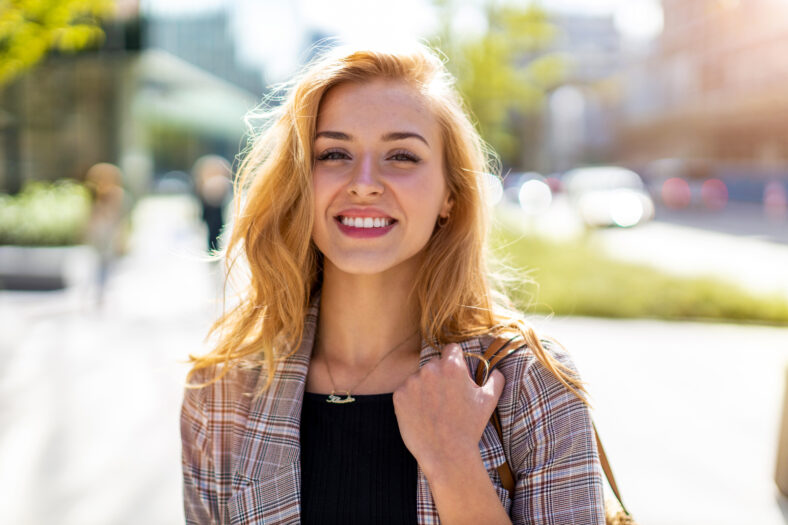 pretty woman smiling while outside in the summer
