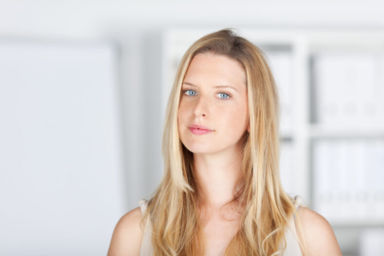 pretty blonde haired woman standing in a white room