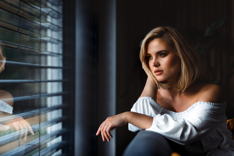 Deep in thought at home pretty young lady sitting on sofa and thinking