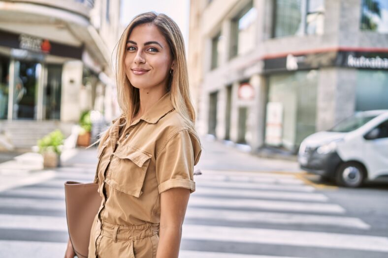 Young blonde girl smiling happy standing at the city.