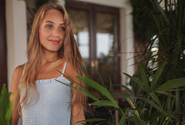 Beautiful young woman standing on indoor terrace