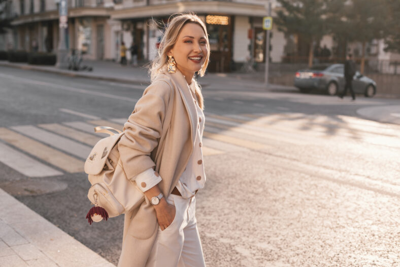 Fashion woman wearing beige trendy coat walking on the street