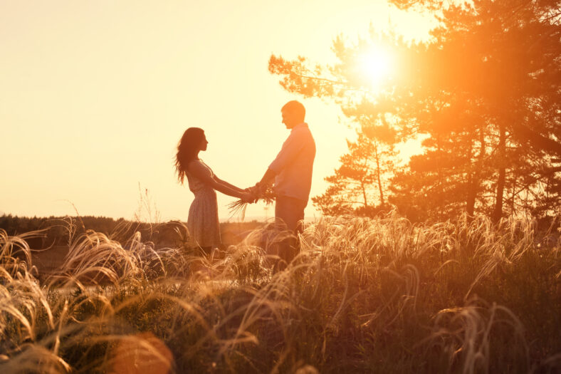 Young couple holding hands at sunrise
