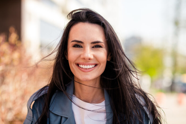 Photo of charming positive woman wear grey trench smiling enjoying good sunny weather outdoors urban city street.