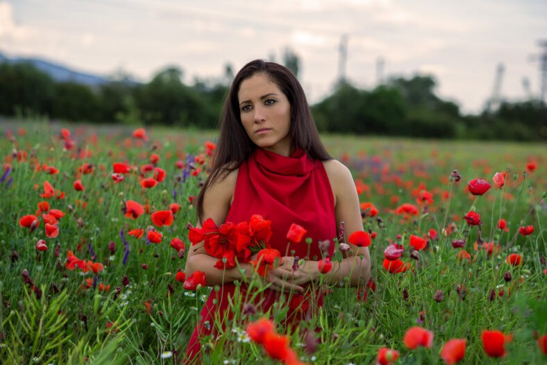 young girl with a beautiful dress in a field of poppies