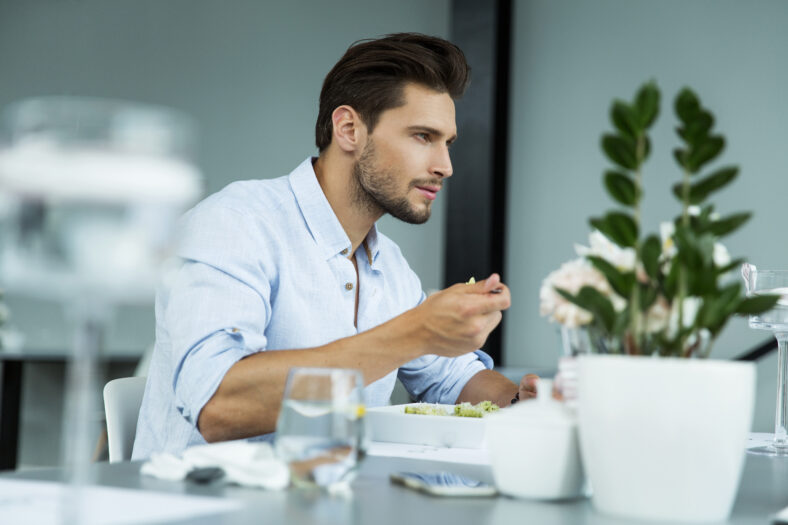 Handsome man eating meal