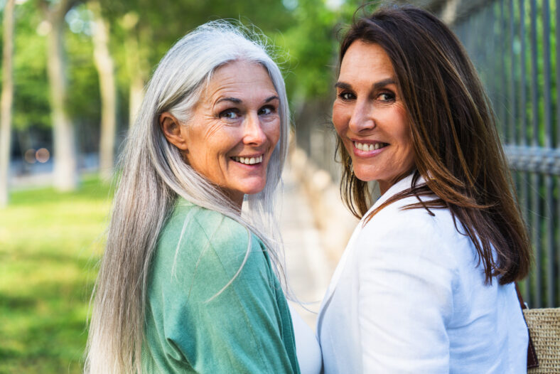 Beautiful senior women bonding outdoors in the city - Attractive cheerful mature female friends having fun, shopping and bonding, concepts about elderly lifestyle