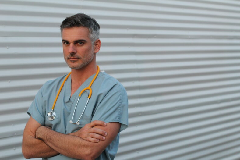 Mature handsome health care worker portrait isolated with arms crossed