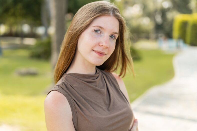 Young French girl at outdoors with arms crossed and looking forward