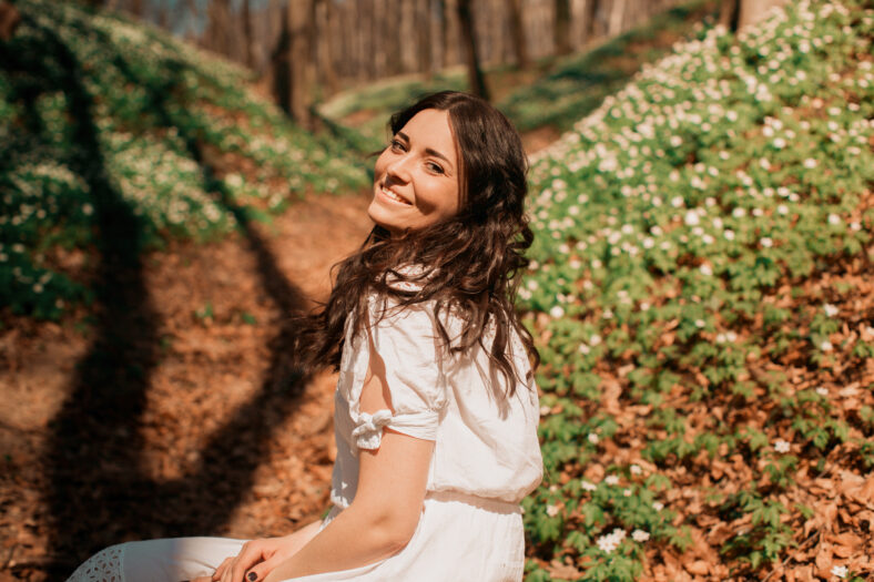 Stunning girl with brown hair sits on the ground