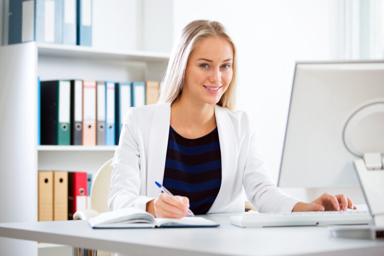 Portrait of a young business woman using computer at office