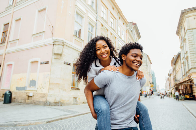 Smiling afro american couple of lovers having fun in city street in summer time -tourism, travel, people, leisure and teenage concept.