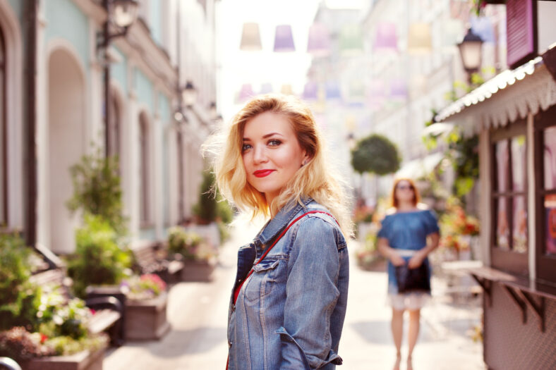 young beautiful girl in a white skirt and a red top. walking in the park and city