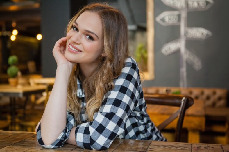 Portrait of young woman sitting at table