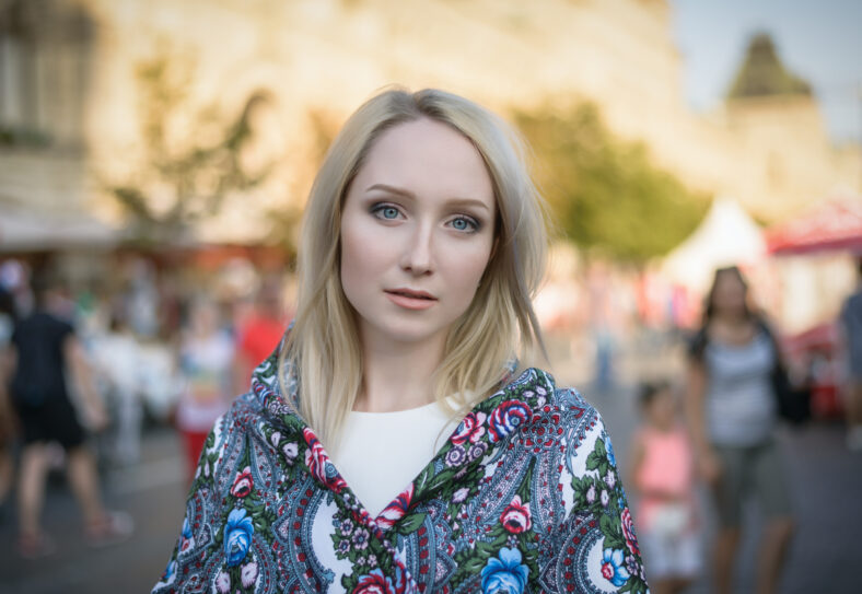 Outdoors portrait of beautiful young woman in the street. Selective focus.