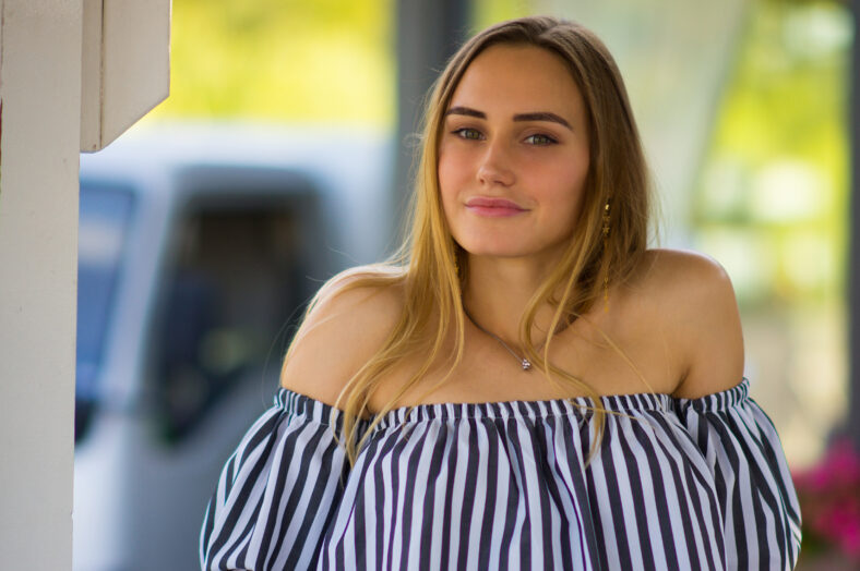 Retrato de una hermosa chica sobre el fondo de la naturaleza de verano en la ciudad