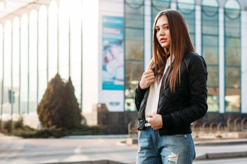 portrait fashionable girl on the street posing looks to camera