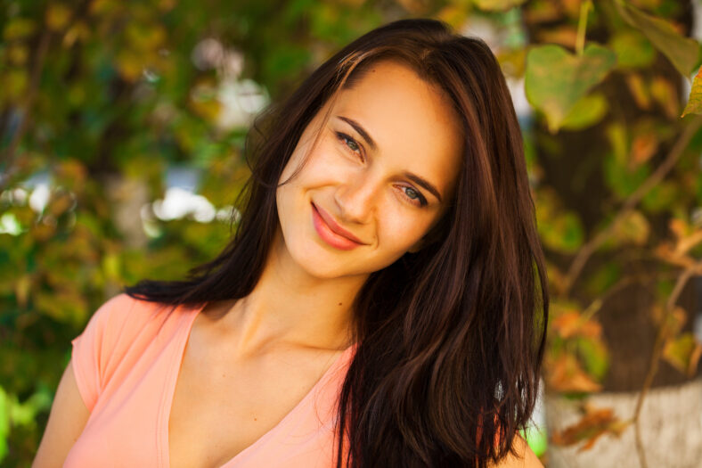 Close up Young brunette woman in summer park