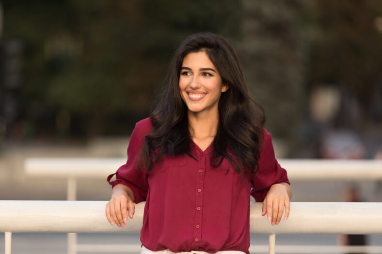 Pretty woman leaning on railing outdoors, walking in city center