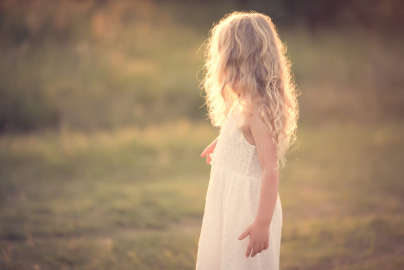 Beautiful blond little girl play in the field
