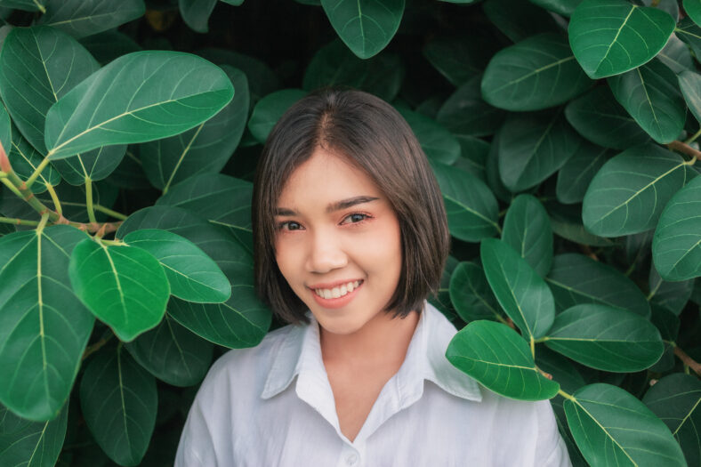 Portrait of an Asian woman in a garden full of leaves