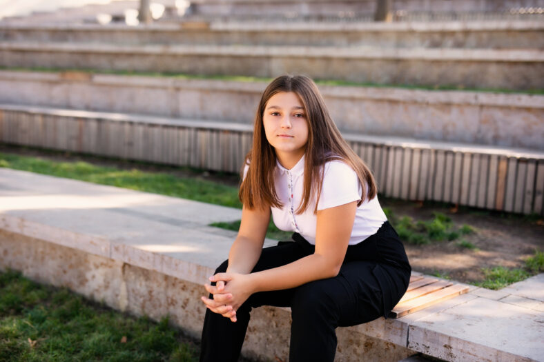 Closeup of teenage girl sitting on a school bench.