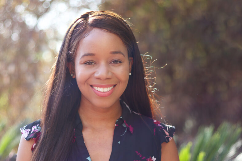 A college-age African American woman looking forward into the camera.