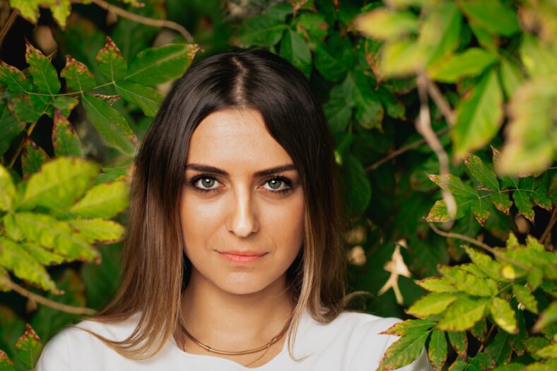 pretty young woman among flowers and trees