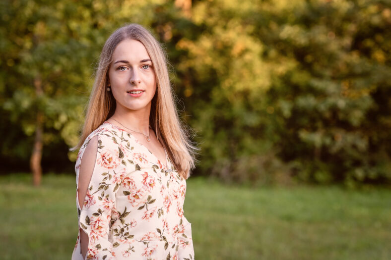 Portrait of a young blonde woman against a defocused landscape. Autumn color shade - image