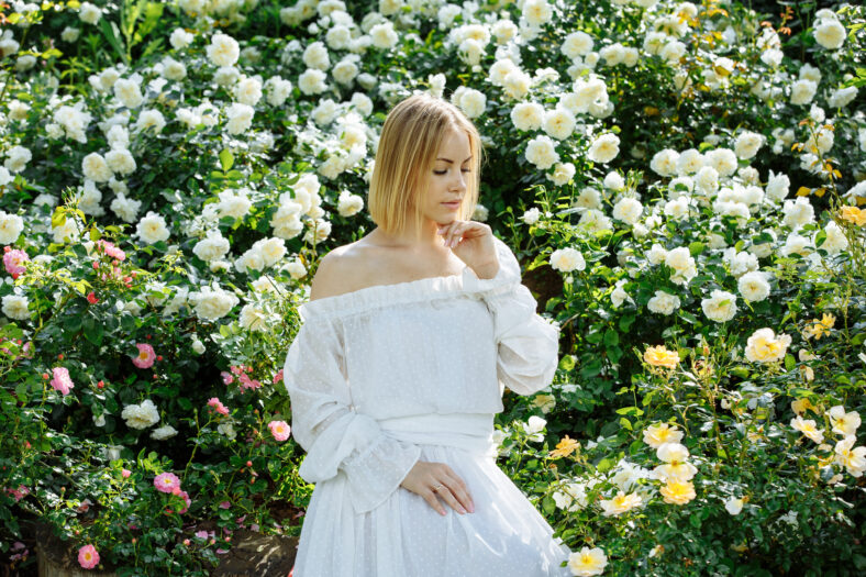 girl in a white dress in the garden with white roses