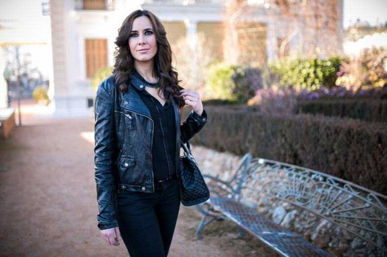 brunette woman dressed in black in a park