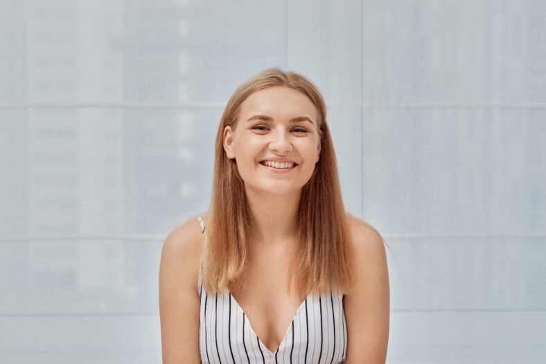 Beautiful young blonde girl smiling and looking at the camera. Portrait of a beautiful young woman.