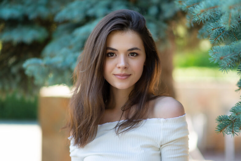 portrait of beautiful brunette woman in summer park
