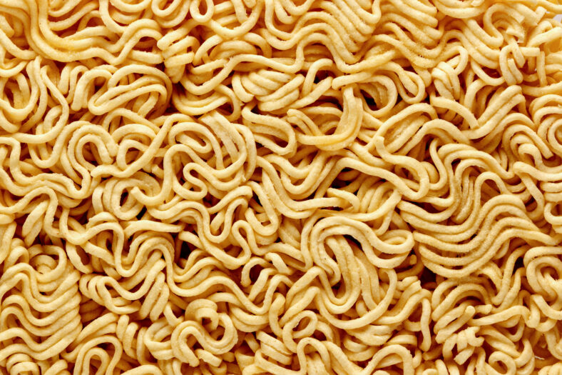 dry raw instant noodles, texture background top view.